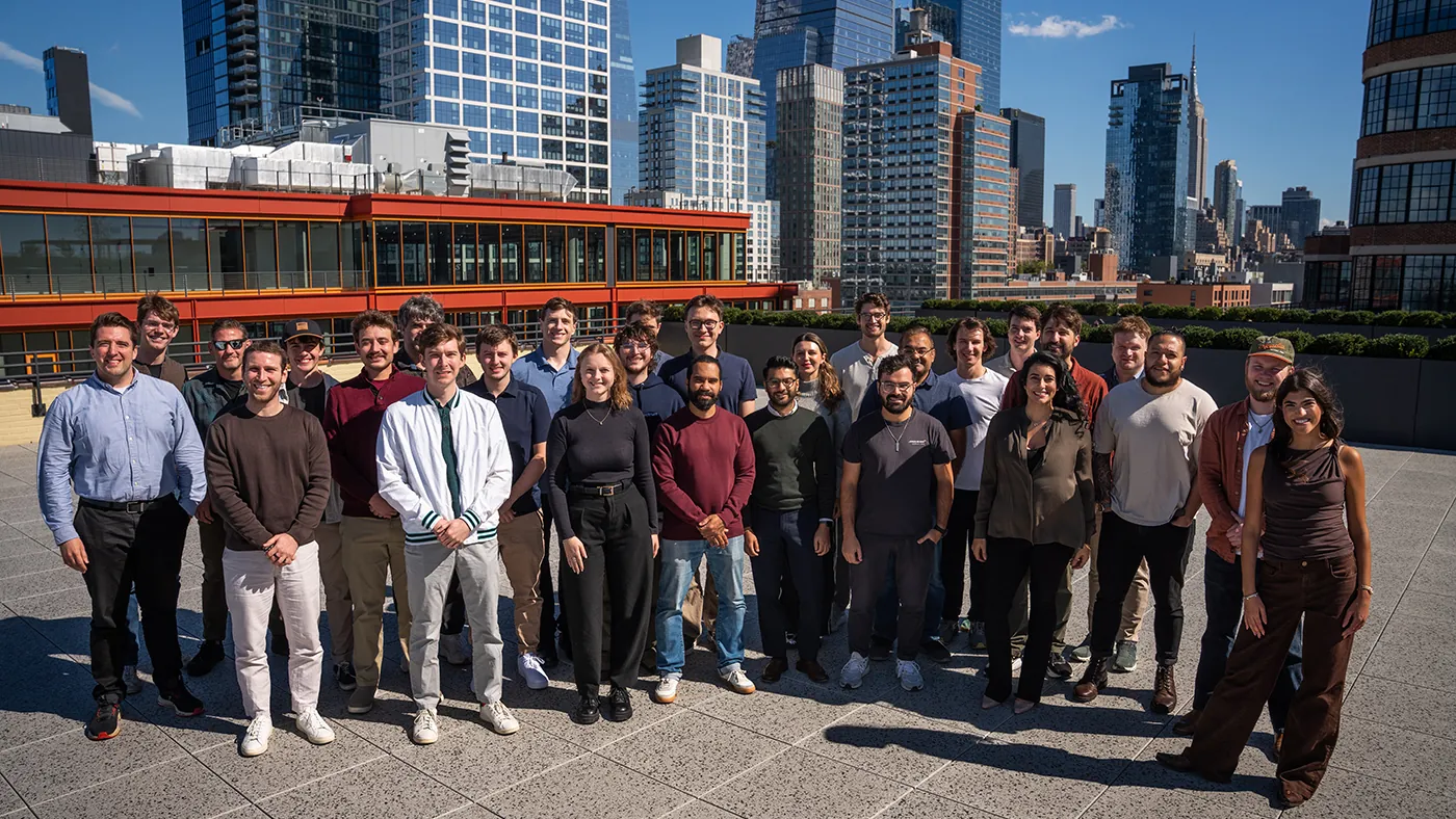 The Distributed Spectrum team together on a rooftop in New York, with the Midtown skyline and the Empire State Building behind them